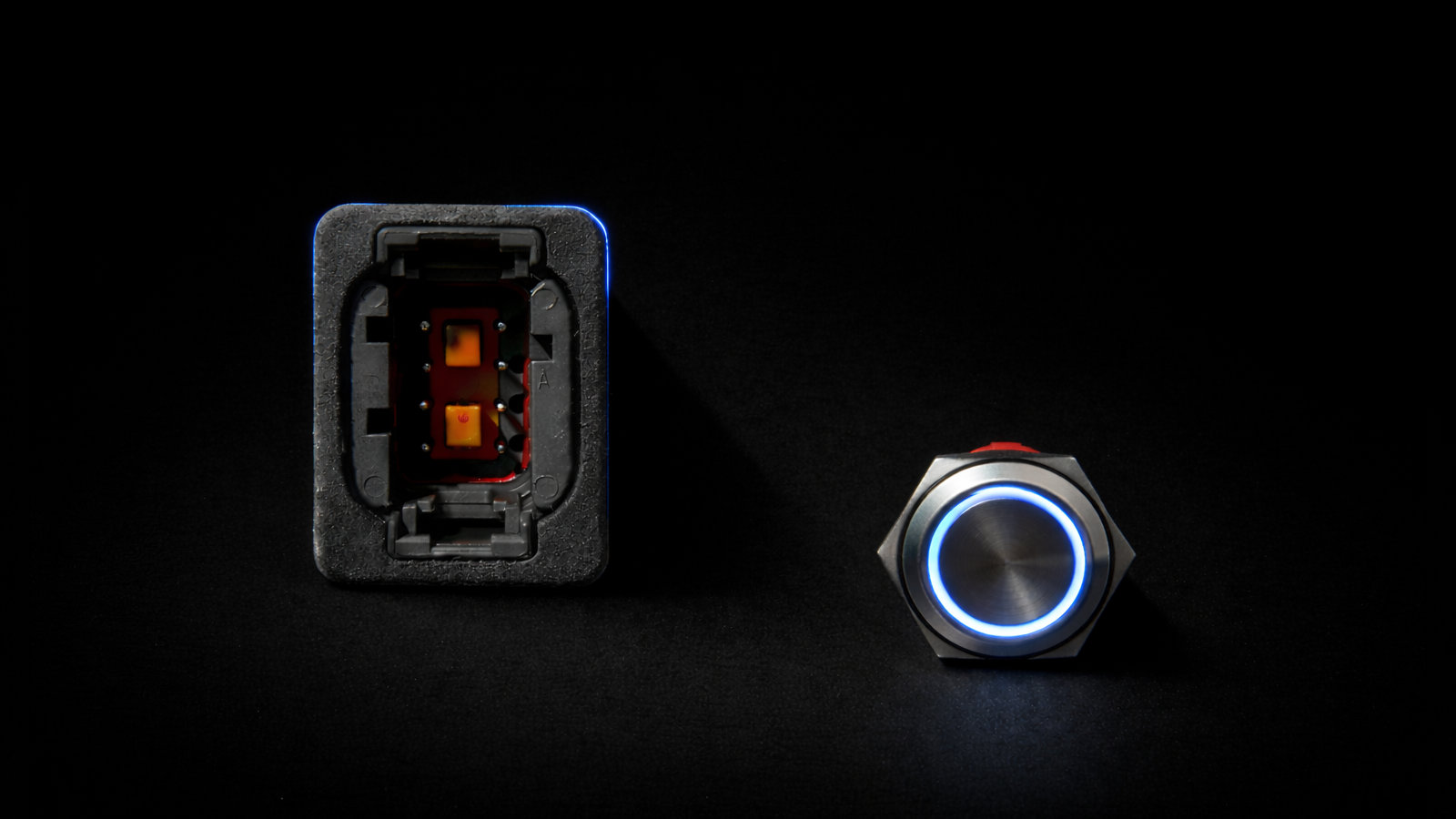 Front view of the XVIA BOD module beside an illuminated metal push button