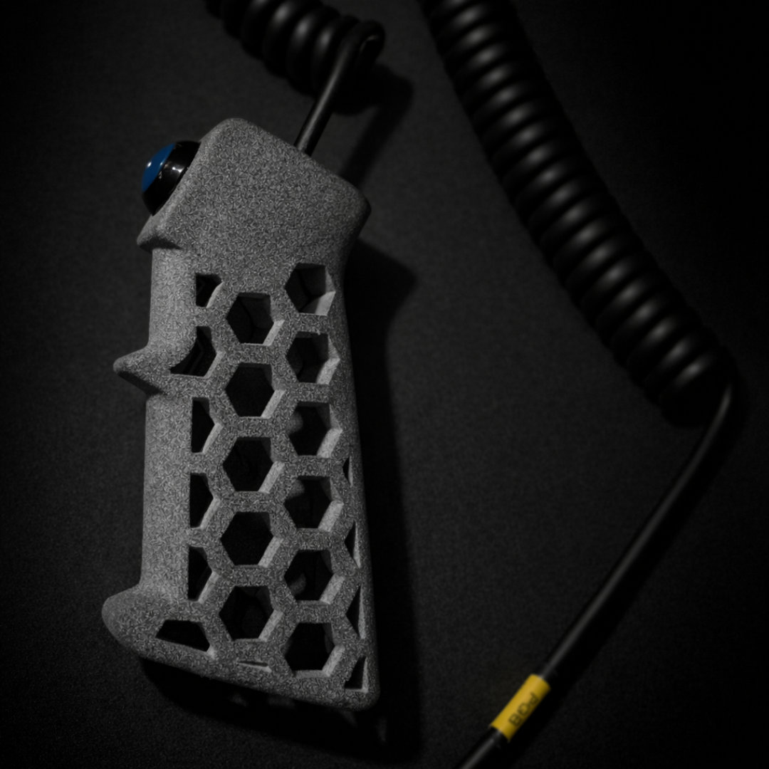Full view of the PGB grip body with honeycomb cutouts and coiled cable